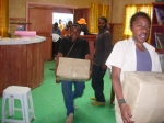 Murphy and the students of Bukapena Primary carry their books into the Library